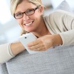 31688465 – blond woman reading text message on smartphone